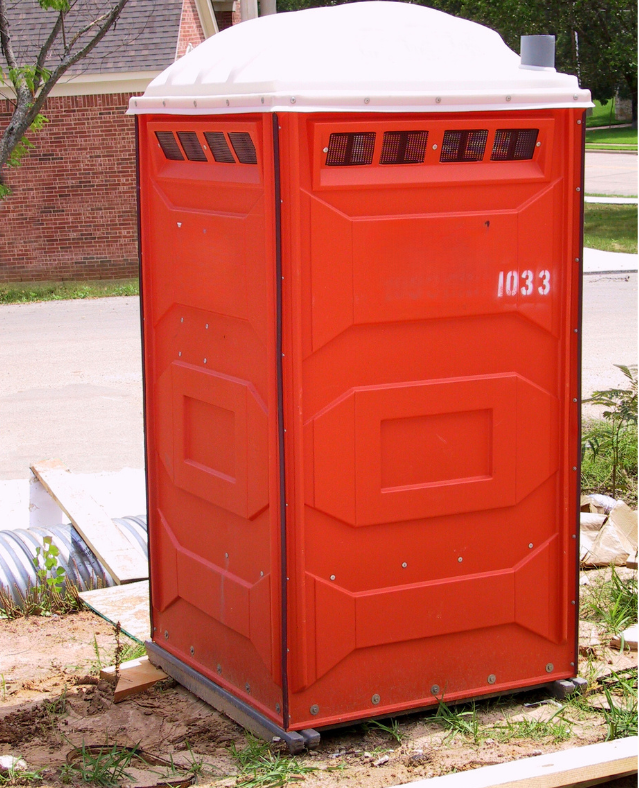 red portable toilet at site
